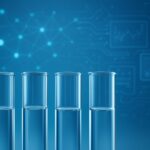 Four transparent test tubes against a blue background with digital circuit patterns and graphs